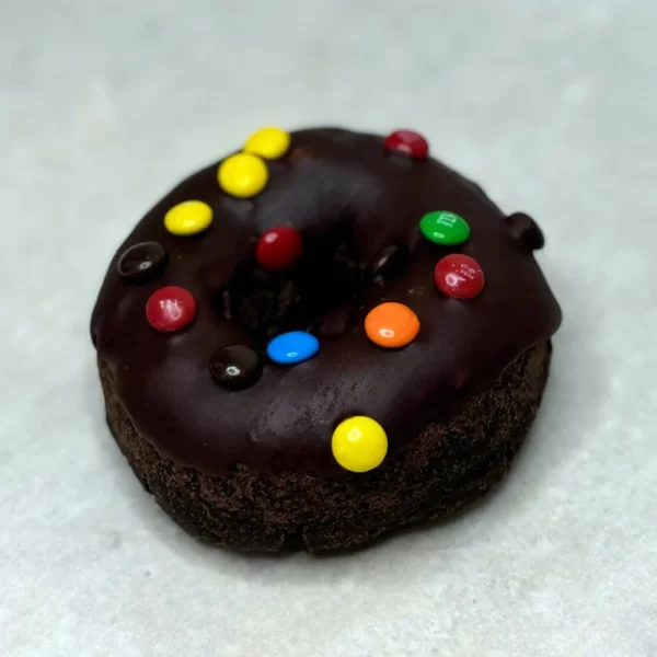 Chocolate cake donut with chocolate icing and M&M