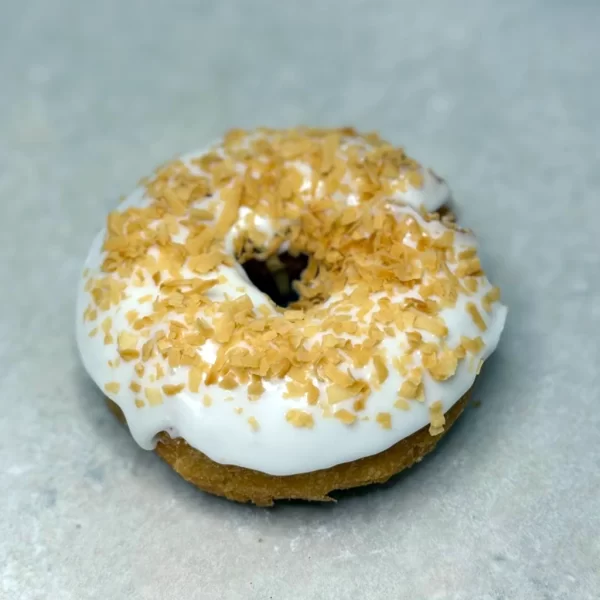 Vanilla cake donut with vanilla icing and assorted toppings